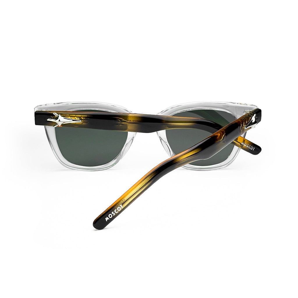 Clear and tortoise acetate sunglasses with dark green lenses, stylish modern eyewear