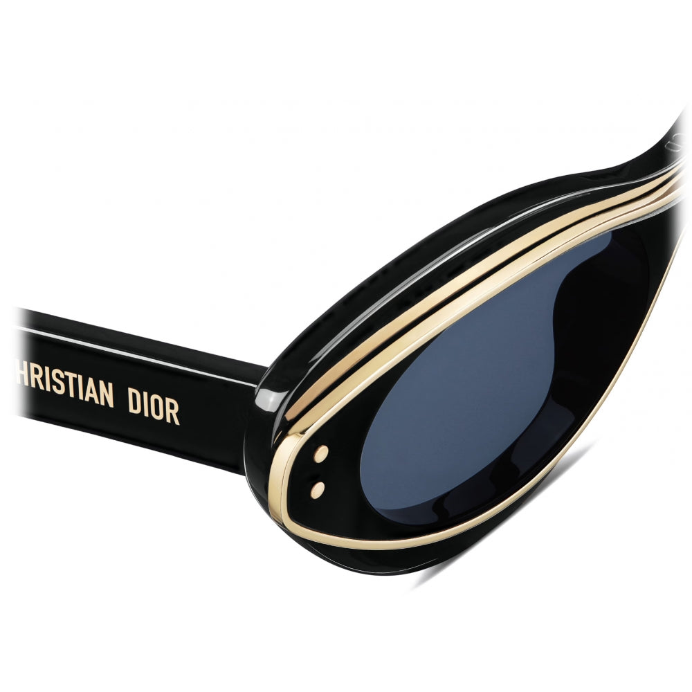 Black sunglasses with gold accents and dark lenses, close-up of distinctive frame details