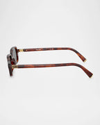 Tortoiseshell rectangular sunglasses with gold accents, side view on white background